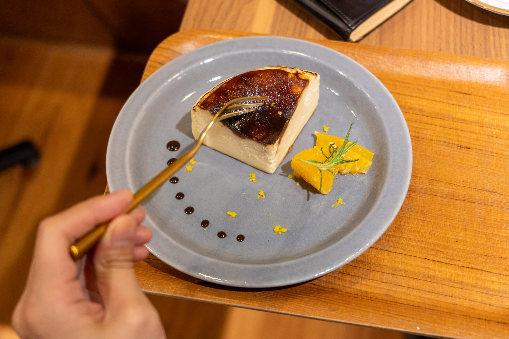 チョコレートソースとオレンジ、ローズマリーを添えたバスクチーズケーキ